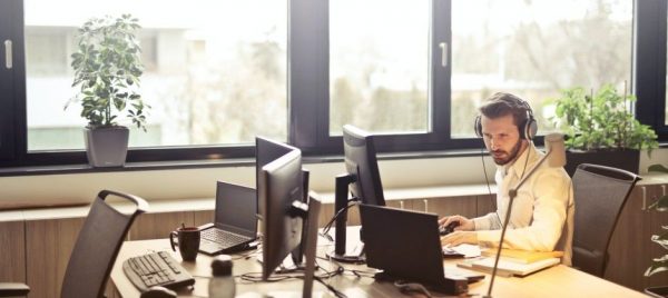 man-with-headphones-facing-computer-monitor